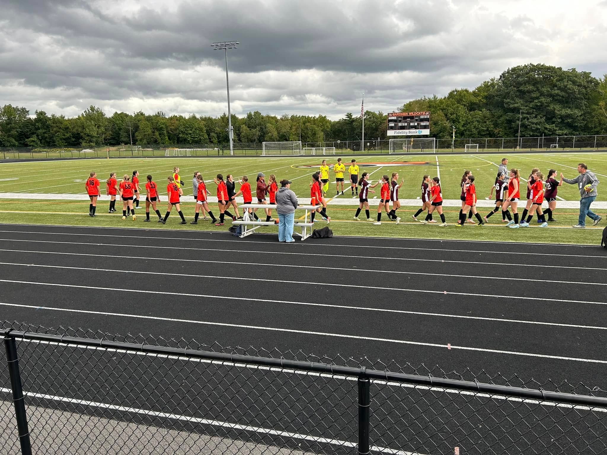 Youth soccer teams gathering on field