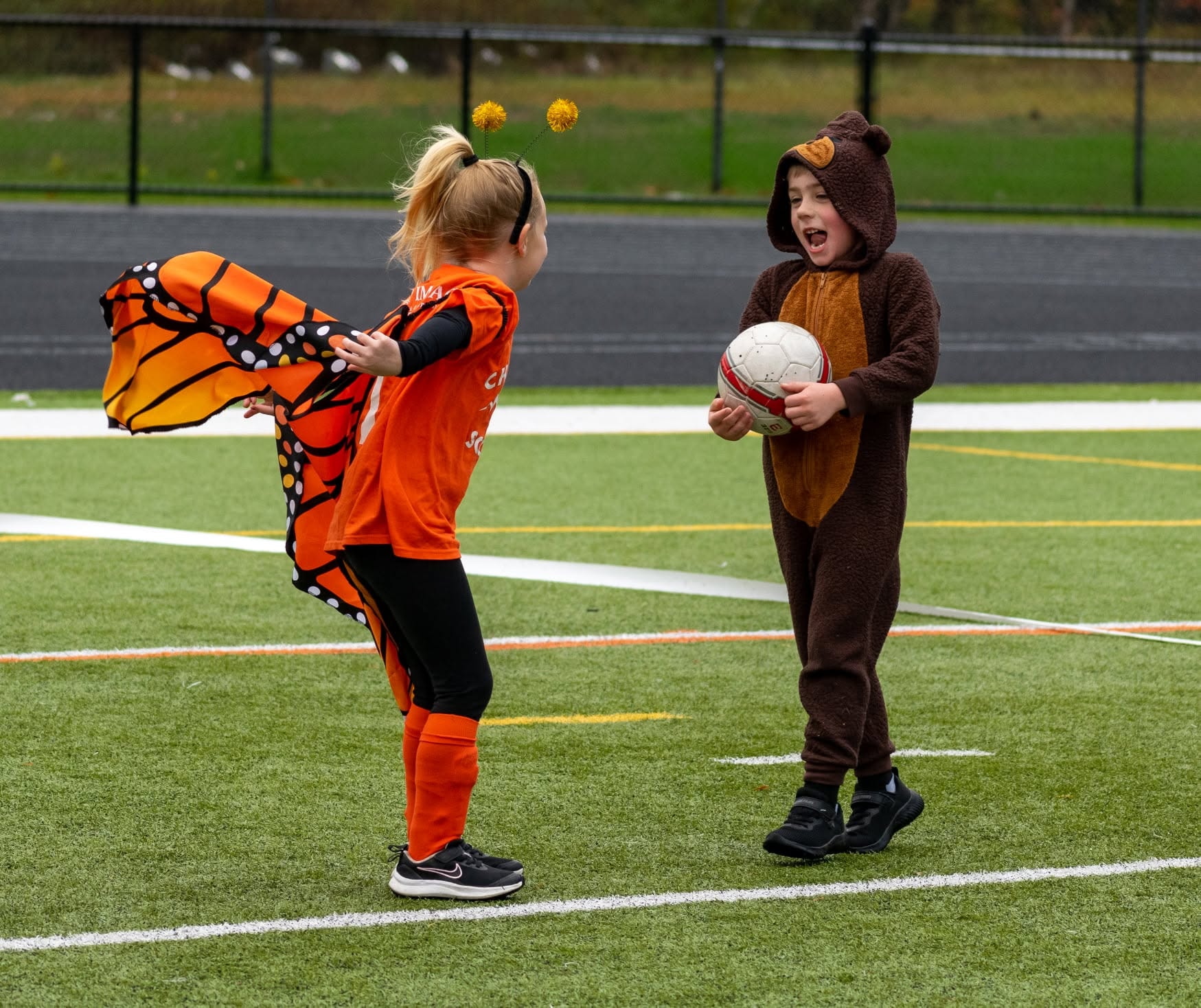 Children in costumes playing soccer